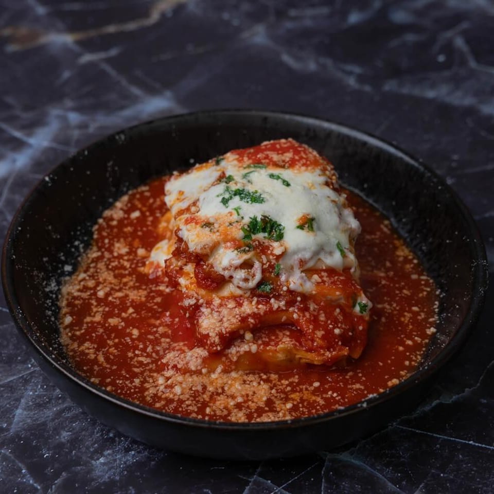 Rocco's Pizza and Italian Kitchen's lasagna, topped with melted cheese, red sauce, and parsley.